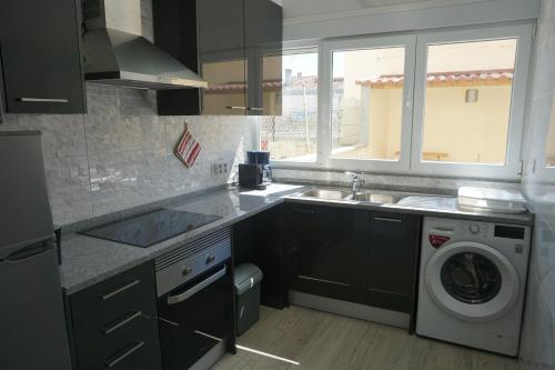 a kitchen with a sink and a washing machine at Sunny Home in Amadora