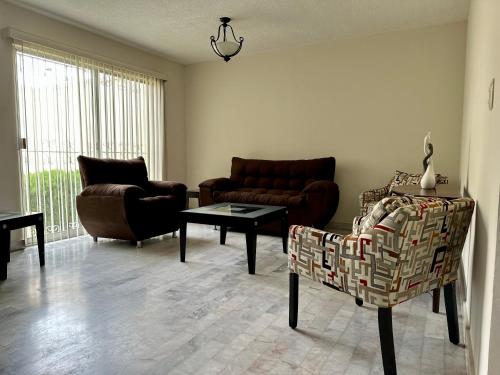 a living room with a couch and chairs and a table at GRAN CASA para vacacionar in Durango