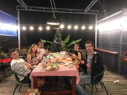 a group of people sitting around a table with food at Charming and Spacious Beach Homestay 4 Rooms 1 Pool Entire Palace in Hà Bàng