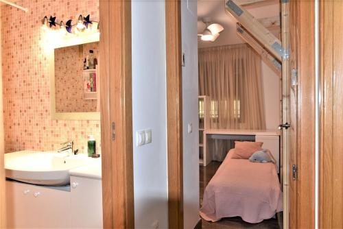 Dormitorio pequeño con cama y lavamanos en Buena vista, en Fuengirola