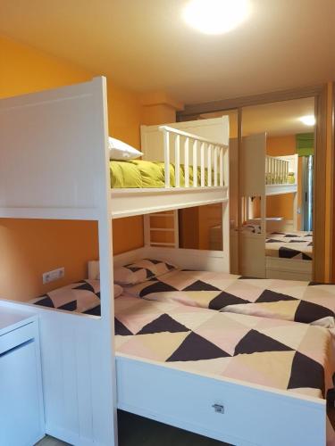 a bedroom with two bunk beds and a mirror at Casa Fandiño in Cangas de Morrazo