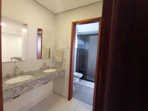 a bathroom with two sinks and a toilet at Miradores del Chaco in Asunción