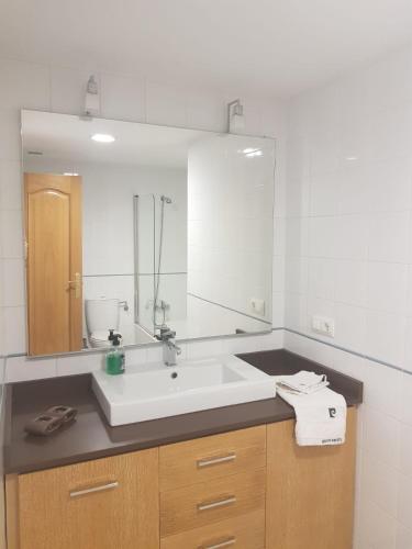 a bathroom with a sink and a large mirror at Casa Fandiño in Cangas de Morrazo