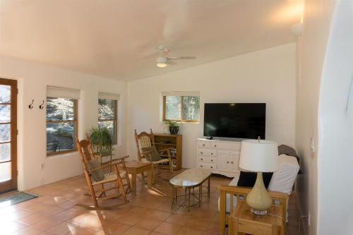 sala de estar con TV, mesa y sillas en Peaceful Santa Fe Forest Home, Comfy and Well-equipped, en Santa Fe