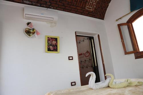 two white swans sitting on a bed in a room at Memnoun house in Luxor