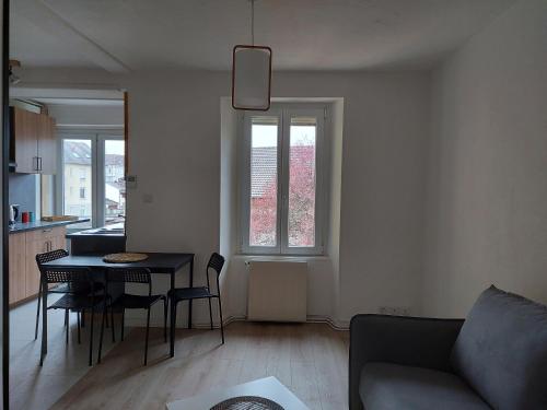 a living room with a table and a couch at Appart'Hotel la Savoureuse in Belfort