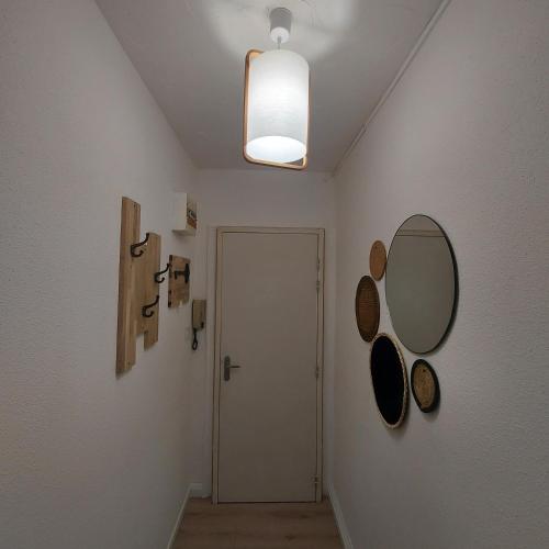 a hallway with a door and a mirror on the wall at Appart'Hotel la Savoureuse in Belfort
