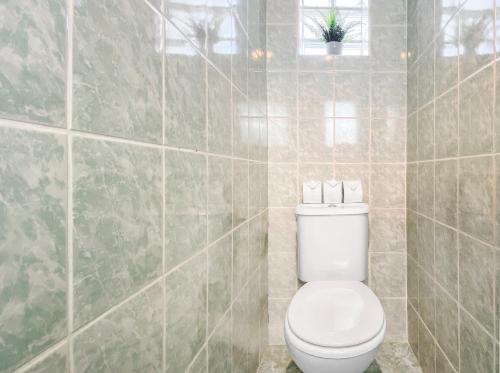 a bathroom with a toilet and a tiled wall at HOMEY Coloc goodLife - Colocation moderne - Chambres privées - Wifi et Netflix - Au pied du tram pour Genève in Ambilly