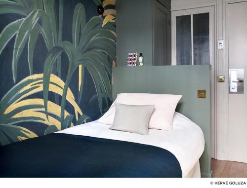 a bed with two pillows on it in a room at Hôtel Henriette in Paris
