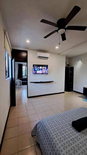 1 dormitorio con ventilador de techo y TV en la pared en Playa Blanca - Moro Blue, en Cancún