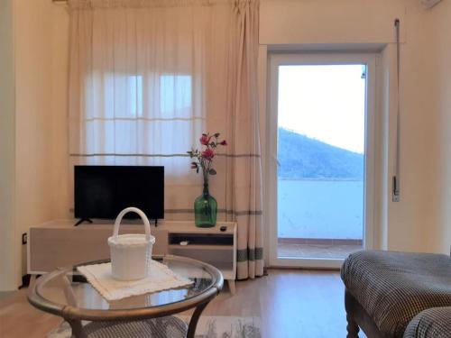 a living room with a glass table and a large window at Moradia Félix - Apartamento Félix in Manteigas
