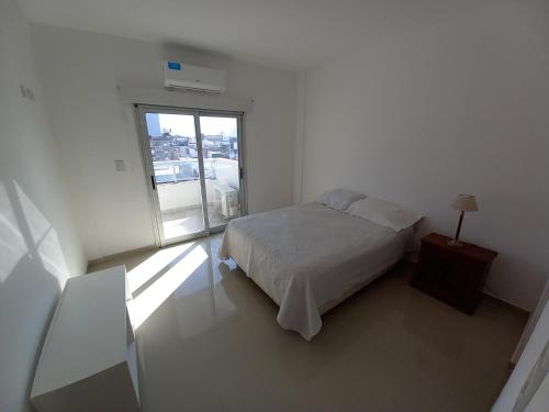 um quarto branco com uma cama e uma janela em Departamento en Corrientes em Corrientes