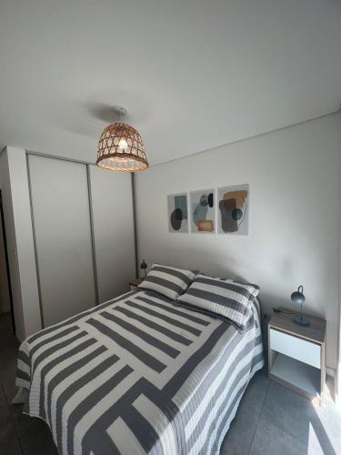 1 dormitorio con 1 cama en blanco y negro y 1 lámpara en Departamento moderno con parrilla privada para 3 en Salta