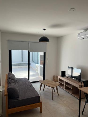 Sala de estar con cama y mesa en Departamento moderno con parrilla privada para 3 en Salta