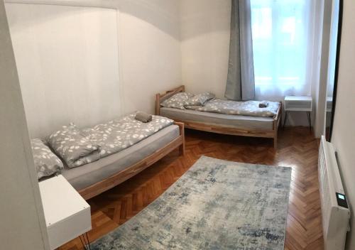 two beds in a room with a rug at Apartment Amra in Sarajevo
