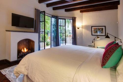 a bedroom with a large bed and a fireplace at ELEGANT HOME WITH STUNNING VISTAS - CASA VALENTINA in San Miguel de Allende
