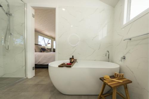 a white bathroom with a tub and a shower at BIG4 River Myall Holiday Resort in Bulahdelah