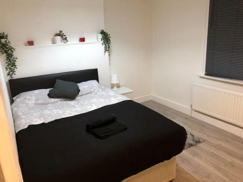 um quarto com uma cama com um edredão preto em Four bedroom property for 10 guests, great location Aldgate E1 close to Tower bridge em Londres