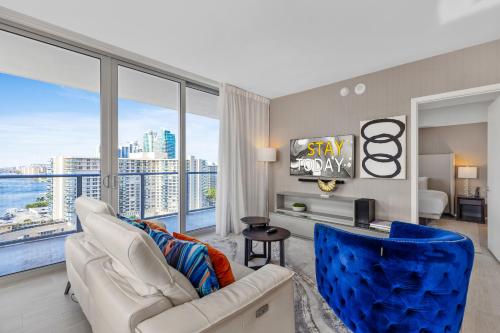 a living room with a white couch and a large window at Hyde Beach House - Stunning 2bd 2ba - Apt - Ocean & Intercostal views in Hollywood