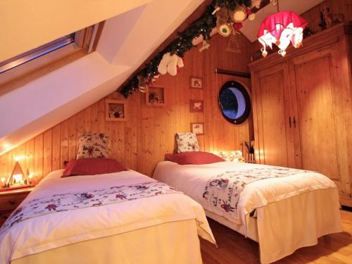 zwei Betten in einem Zimmer mit Holzwänden in der Unterkunft Charmant Gîte au Cœur de la Nature Alsacienne - FR-1-589-224 in Provenchères-sur-Fave