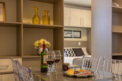 a dining room with a table with wine glasses at Pôr do sol 18º andar vista da cidade CENTRAL, Garagem NOVO in Passo Fundo
