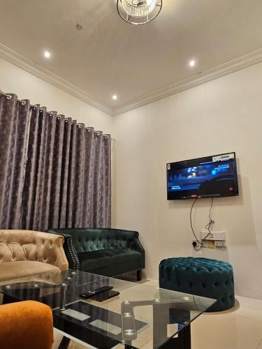 a living room with two green couches and a tv at تاج الكورنيش عجمان in Ajman 