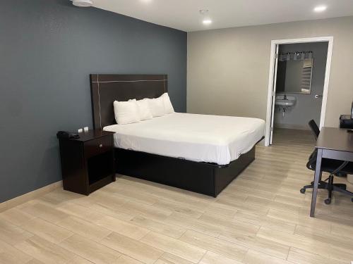 a bedroom with a large bed and a desk and a desk at Falcon Executive Inn in Zapata