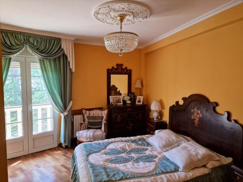 1 dormitorio con cama, espejo y lámpara de araña en 4 bedrooms property with enclosed garden and wifi at Congosto, 
