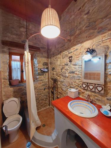 a stone bathroom with a sink and a toilet at Large Stone Villa with garden. in Khánia