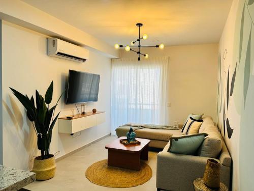 a living room with a couch and a tv at alberca tipo playa,10 min de la playa by G P S rentas in Mazatlán