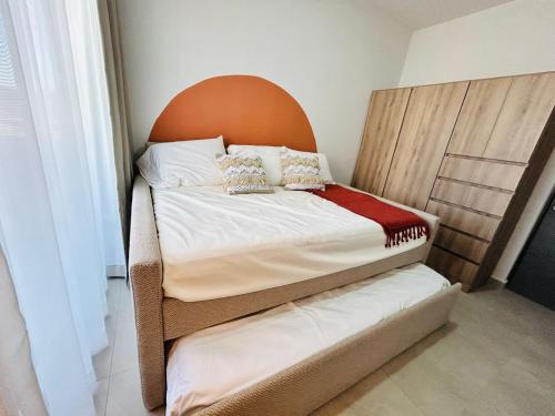 a small bed with a headboard in a room at alberca tipo playa,10 min de la playa by G P S rentas in Mazatlán
