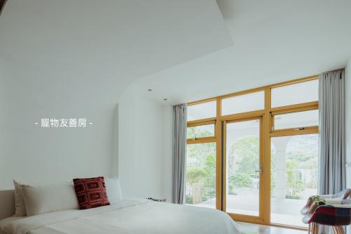 a bedroom with a bed and a large window at 湖畔莊園 道 Villa in Dongshan