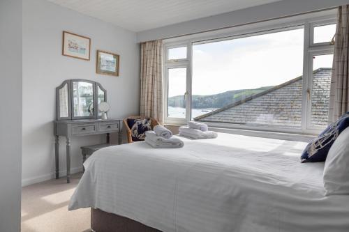 a bedroom with a bed and a large window at 2 Church Hill House in Salcombe