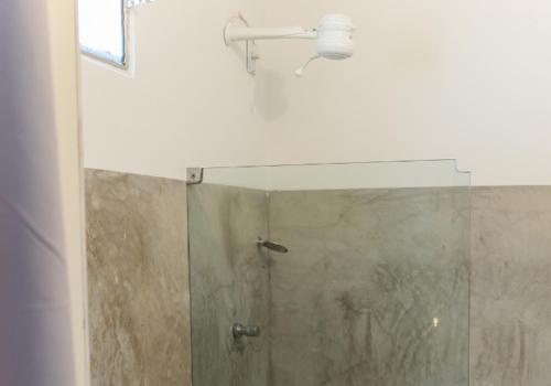 ein Bad mit einer Dusche und einer Glastür in der Unterkunft casa jasmin in Jericoacoara