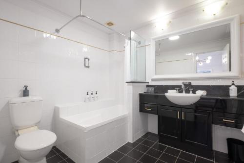 Un baño con un inodoro blanco y un lavabo. en St Tropez, en Brisbane