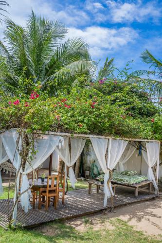 a house with a table and chairs and flowers at casa jasmin in Jericoacoara