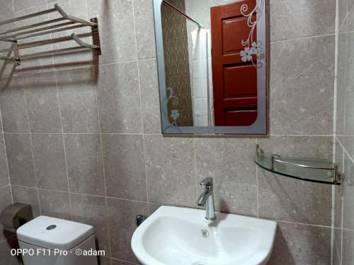 a bathroom with a sink and a mirror and a toilet at Senja Bay Resort in Perhentian Island