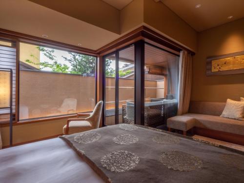 a bedroom with a bed and a window and a couch at Sora Niwa Terrace Kyoto Bettei in Kyoto
