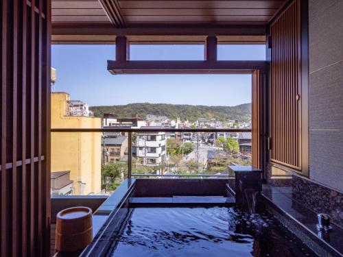 uma casa de banho com banheira e vista para a cidade em Sora Niwa Terrace Kyoto Bettei em Quioto