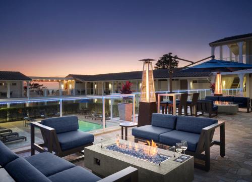 a patio with couches and a table and a pool at Hotel Indigo San Diego Del Mar by IHG in San Diego
