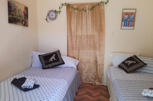 a bedroom with two beds and a window with a curtain at Cocoa Cabana in Scarborough