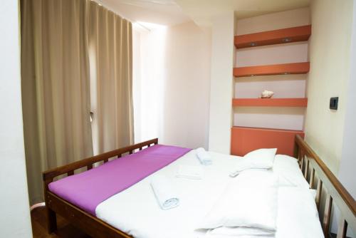 a bedroom with a bed with a purple blanket at Vila Centar in Budva
