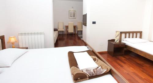 a room with two beds and a table and chairs at Vila Centar in Budva