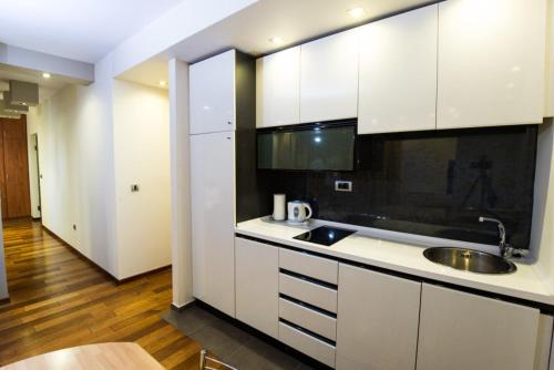 a kitchen with white cabinets and a sink at Vila Centar in Budva