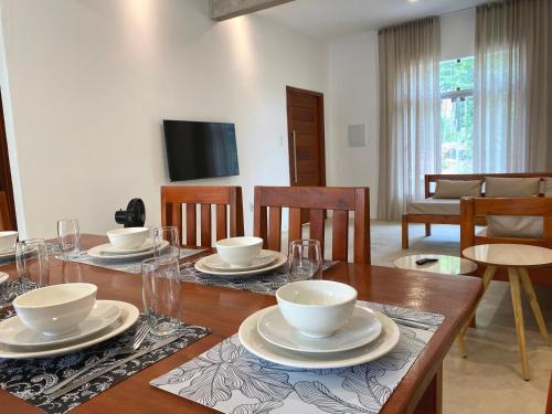 Casa do Villas - Arraial d'Ajuda في ارايال دايودا: غرفة طعام مع طاولة مع كراسي وتلفزيون