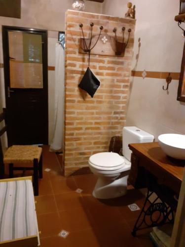 La salle de bains est pourvue de toilettes blanches et d'un lavabo. dans l'établissement INFINITO YO, espacio pensado para mujeres solas o con su pareja, à Carmelo