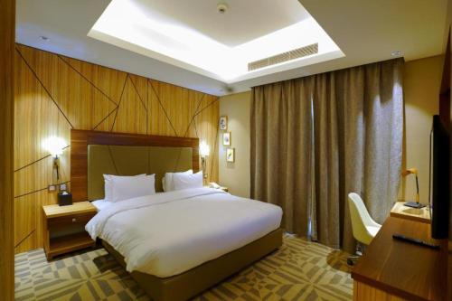 a hotel room with a large bed and a television at Al Aseel Hotel in Doha