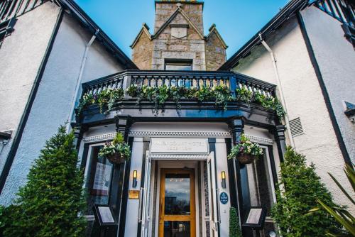 a building with a balcony with plants on it at Palm Court Hotel in Aberdeen