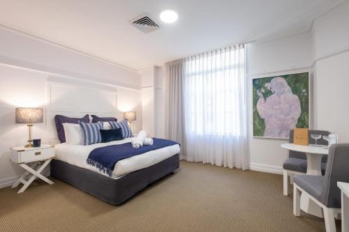 a bedroom with a bed and a desk and a window at Ciao Bella in Brisbane