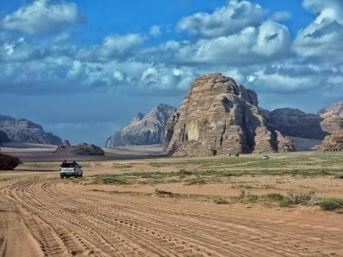 a truck driving down a dirt road in the desert at Salma Desert Camp in Wadi Rum